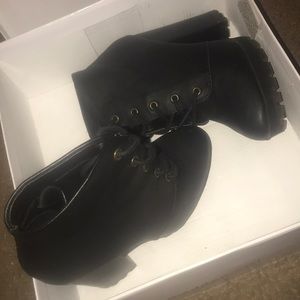 black , leather like high heel boots .